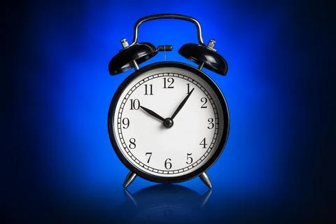 Alarm clock on blue background. Stock Photos