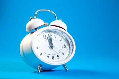 Alarm clock on blue background. Time concept. Copy space. Stock Photos