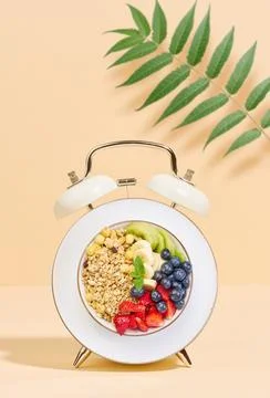 Alarm clock with a bowl instead of a clock face. The bowl is filled with di.. 스톡 사진