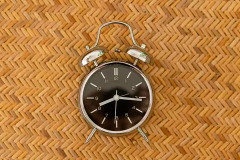 Alarm clock on braided texture. Start work concept. Stock Photos