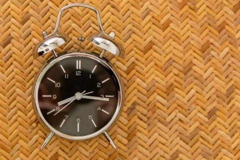 Alarm clock on braided texture. Start work concept. Stock Photos