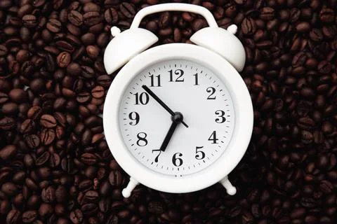 Alarm clock on coffee bean background close-up Stock Photos