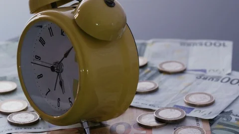 Alarm clock on coins and banknotes Stock Footage 86571017