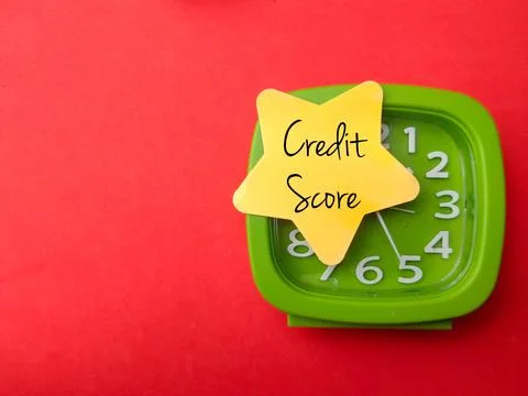 Alarm clock with colored sticky note with text Credit Score Stock Photos