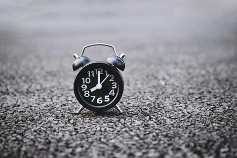 Alarm clock on the dark rough texture background with copy space. Stock-Fotos