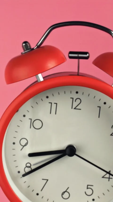 The alarm clock flies up on a pink background. Filmed on a high-speed camera at Stock Footage 335381131