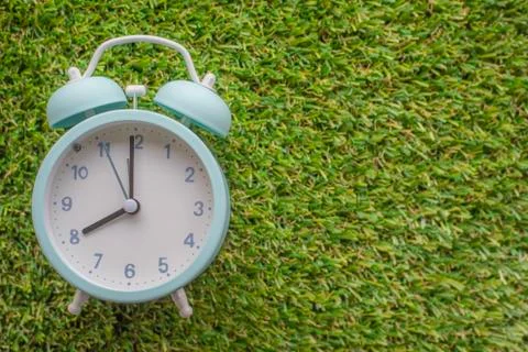 Alarm clock on grass background Stock Photos