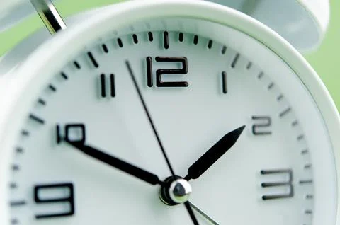 Alarm clock on green background time concept working with time precious time Stock Photos