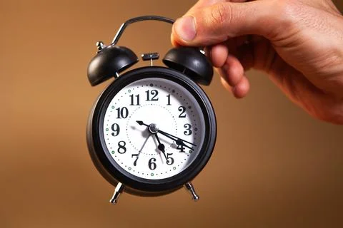 Alarm clock in hand on white background Stock Photos