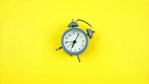 The alarm clock jumps on a yellow background, approaching the camera.Stop motion Stock Footage 171543020