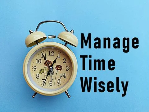 Alarm clock on a light blue background with the words manage time wisely Stock Photos