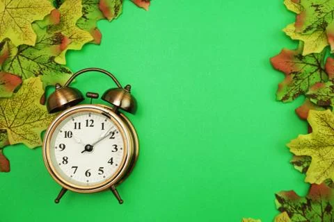 Alarm clock with Maple leaf boder on green background 库存照片
