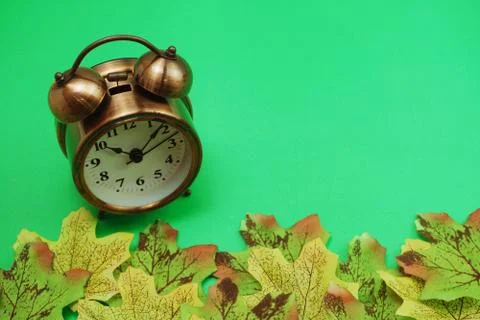 Alarm clock with Maple leaf boder on green background 库存照片