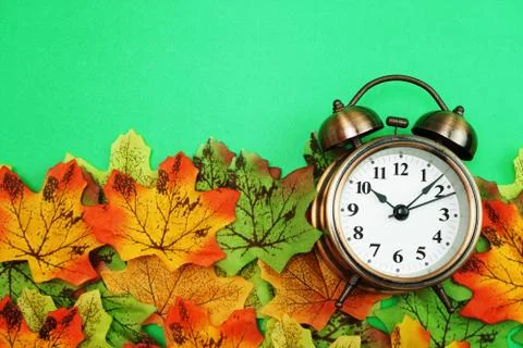 Alarm clock with Maple leaf boder on green background 库存照片