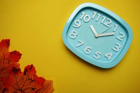 Alarm clock with Maple leaf boder on Yellow background Stock Photos