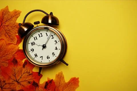 Alarm clock with Maple leaf boder on Yellow background 库存照片