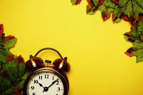 Alarm clock with Maple leaf boder on Yellow background 库存照片