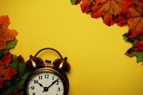 Alarm clock with Maple leaf boder on Yellow background 库存照片