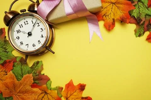Alarm clock with Maple leaf boder on Yellow background Stock Photos