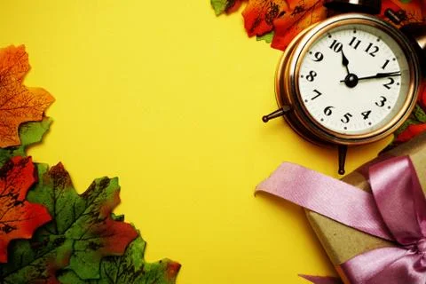 Alarm clock with Maple leaf boder on Yellow background Stock Photos