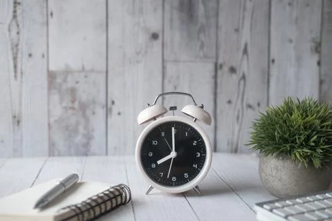 Alarm clock ,notepad and pen on table Stock Photos