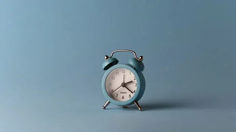 Alarm clock over a blue solid colour background Stock Footage 231950939
