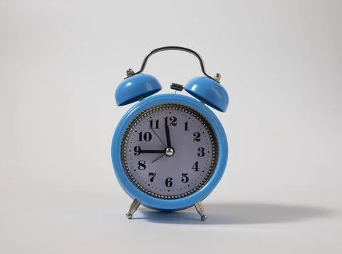 Alarm clock over white. Time concept. Blue alarm clock morning time. Stock Photos