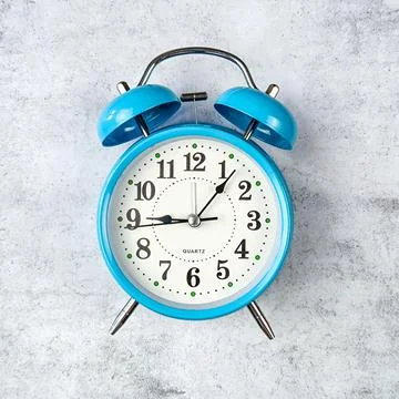 An alarm clock placed on a gray background Stock Photos