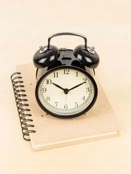 Alarm clock on ring binder book or notebook Stock Photos