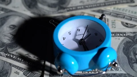 Alarm clock rotates with dollar bills 库存影片 120544010
