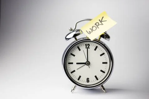 Alarm clock with sticky paper note on white background.. Stock Photos