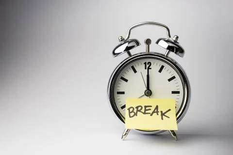 Alarm clock with sticky paper note on white background.. Stock Photos