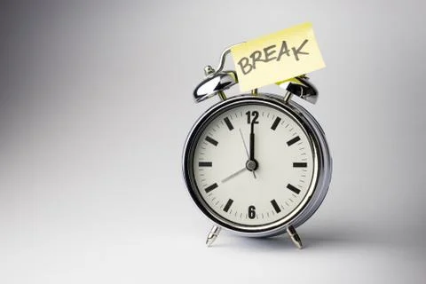 Alarm clock with sticky paper note on white background.. Stock Photos