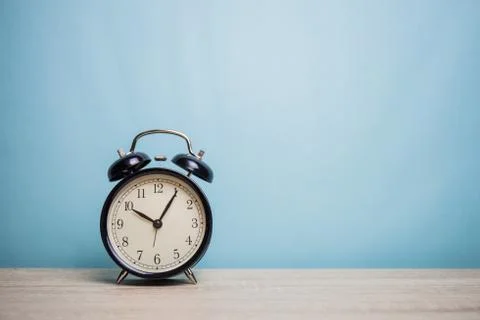Alarm clock on table front mint blue background Stock Photos
