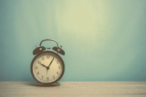 Alarm clock on table front mint blue background Stock Photos