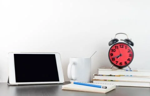 Alarm clock with tablet on office table Stock Photos