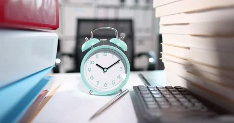 Alarm clock for ten o'clock on desktop with lot of documents closeup Stock Footage 169638063