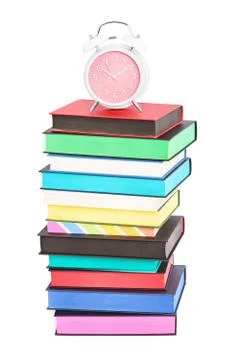 An alarm clock on top of stack of colorful books Stock Photos