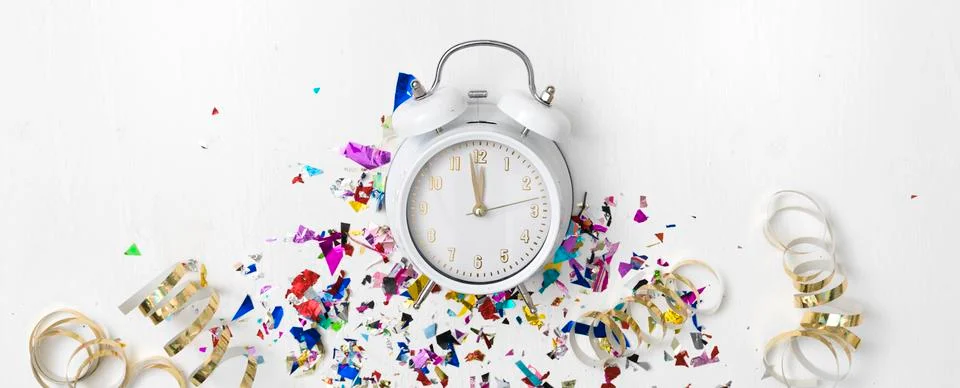 Alarm clock on white background with different colorful new year items Foto stock