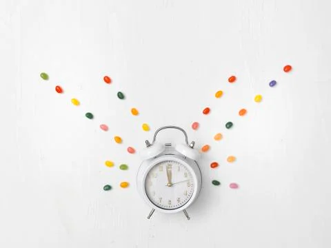 Alarm clock on white background with different colorful new year items Stock Photos