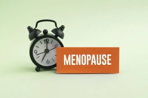 Alarm clock with the word MENOPAUSE, representing the menopause journey and.. Photos