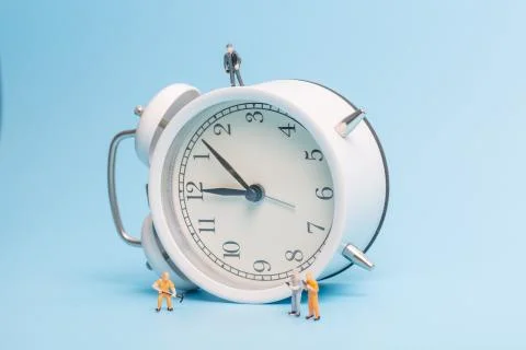 Alarm clock worker on blue background Stock Photos