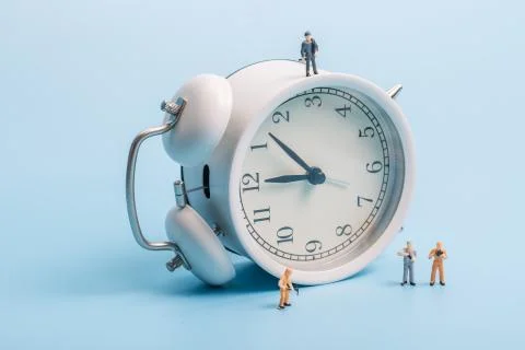 Alarm clock worker on blue background Stock Photos