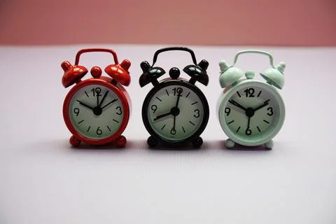 Alarm clocks with different time composition on pink  background Stockfoto's