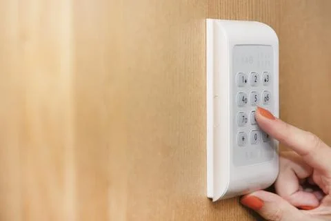 Alarm panel. The hand enters the code from the house security alarm. Real estate Stock Photos