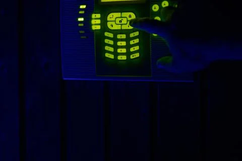 Alarm system control keypad with glowing green led at dark night Stock Photos