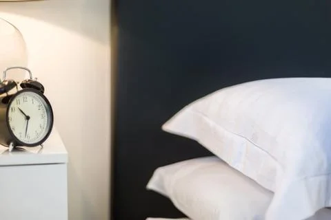 Alarmclock on Side Table and Touch Pillows Stock Photos