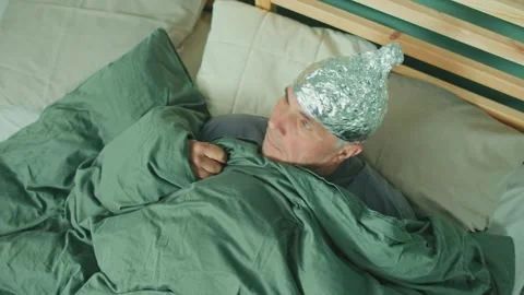 An Alarmed Man in a Foil Cap Suffering from Depression and Paranoia Video stock 166707654