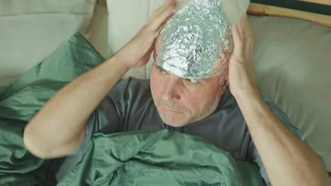 An Alarmed Man in a Foil Cap Suffering from Depression and Paranoia Video stock 171009732