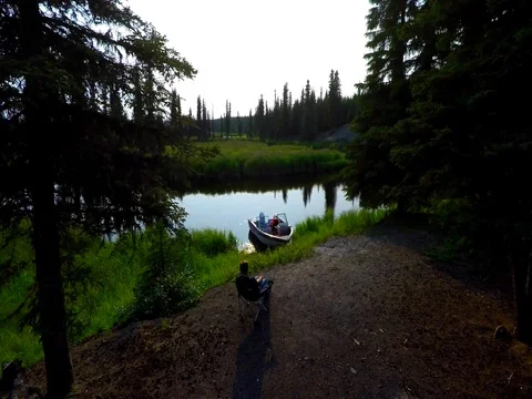 Alaska Moose River tracking over campsite with boat and glass river Stock Footage 78591043